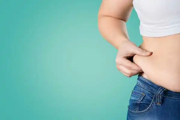Image of woman pinching her love handles to show weight gain Great Yarmouth